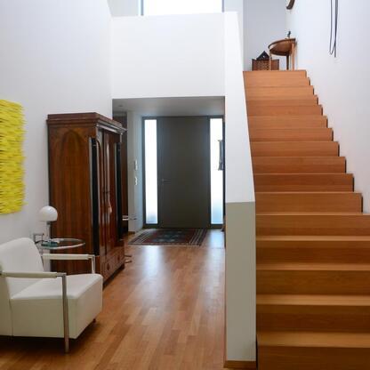 Moderner Treppenaufgang Moderner Treppenaufgang mit Holzstufen und weißer Wand