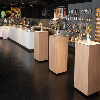 Holztresen im Verkaufsbereich Holztresen im Verkaufsbereich neben weißer Theke