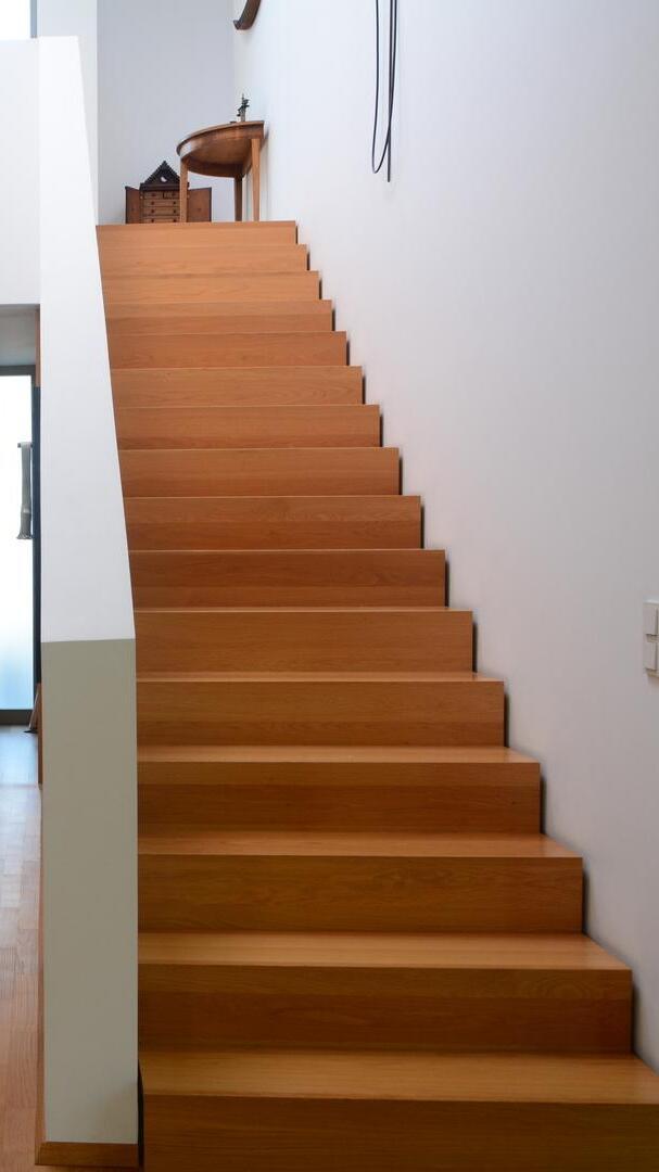 Moderner Treppenaufgang Moderner Treppenaufgang mit Holzstufen und weißer Wand