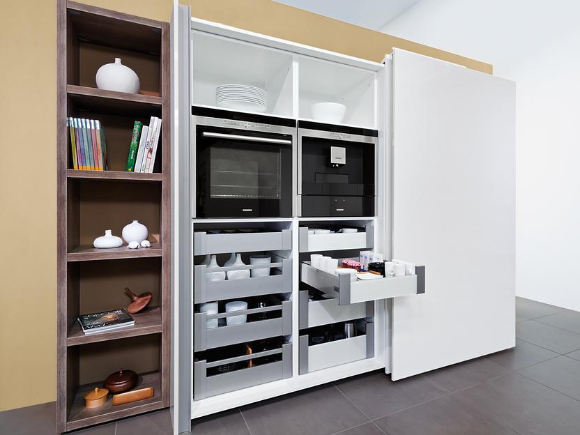 Detailaufnahme eines Küchenschrankes mit Schiebetür, verstecktem Ofen und Mikrowelle und Schubladenelementen