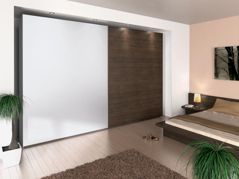 Schlafzimmerimpression mit Einbauschiebetürenschrank in weißer und dunkler Lackierung kombiniert.